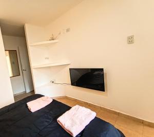 a bedroom with a bed and a flat screen tv at La Morenita dos dormitorios in Chilecito