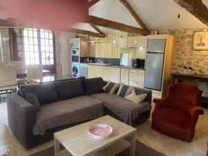 a living room with a couch and a kitchen at La Mouline in Labastide-du-Vert