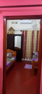 a small room with two beds and a mirror at Reegina Villa in Chunnakam