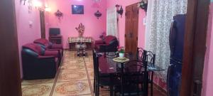 a living room with pink walls and chairs and a table at Reegina Villa in Chunnakam