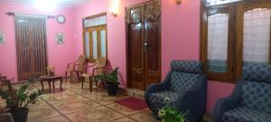 a waiting room with chairs and tables and pink walls at Reegina Villa in Chunnakam