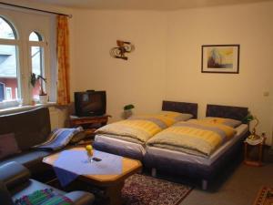 a living room with two beds and a couch at Hotel-Pension Königswald in Dresden