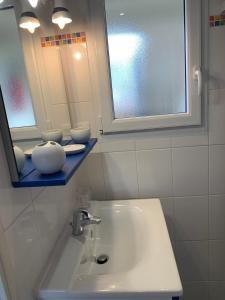 a bathroom with a sink and a mirror at Waterfront studio with small garden, pool, parking in Guidel +6 photos