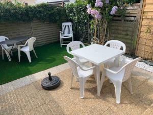 a white table and chairs on a patio at Waterfront studio with small garden, pool, parking in Guidel
