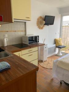 a kitchen with a microwave on a counter top at Waterfront studio with small garden, pool, parking in Guidel