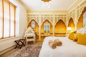 a bedroom with yellow walls and a bed with hats on it at Thomas Paine Hotel in Thetford +34 photos