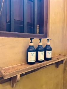 a row of four bottles sitting on a shelf at Ceylon Little Paradise in Hikkaduwa