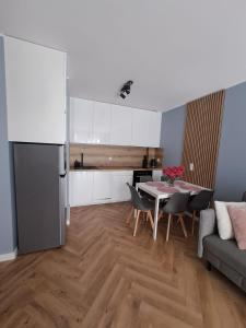 a kitchen and living room with a table and chairs at E&M-Plażowa in Międzywodzie +5 photos