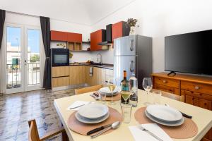 a kitchen with a table with plates and wine glasses at Sinedda Sole in San Vito lo Capo