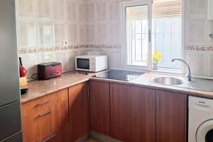 a kitchen with a sink and a microwave at las olas in Chipiona