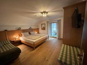a large bedroom with a bed and a window at Frühholz - Das Ferienhaus - in Grainau
