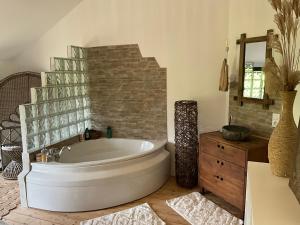a large bathroom with a tub and a mirror at Hameau Fleuri in Pierrefitte-en-Auge +32 photos