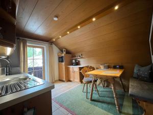 a kitchen with a wooden ceiling and a table at Frühholz - Das Ferienhaus - in Grainau