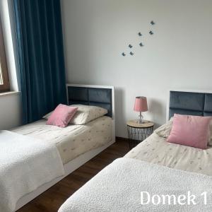 a bedroom with two beds with pink pillows at Apartamenty Ku Dolinie in Wilków