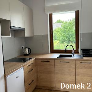 a kitchen with a sink and a window at Apartamenty Ku Dolinie in Wilków