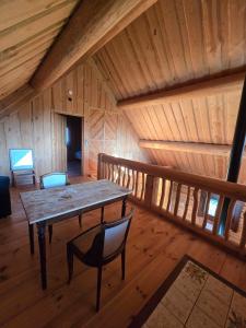 a wooden room with a table and chairs in a cabin at Charmante Fuste in Lubersac