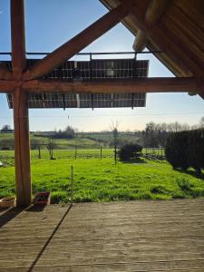 a view of a field from a wooden deck at Charmante Fuste in Lubersac