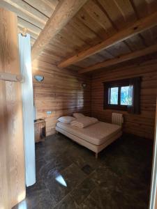 a bedroom with a bed in a wooden cabin at Charmante Fuste in Lubersac