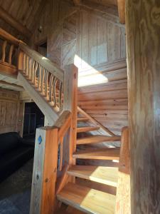 a wooden staircase in a log cabin at Charmante Fuste in Lubersac