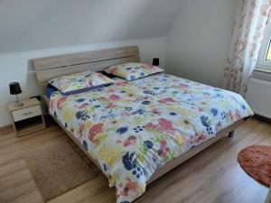 a bedroom with a bed with a floral comforter at Ferienwohnung Twete in Detmold
