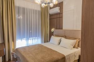 a bedroom with a bed with a chandelier and a window at Lux residence Adrijana 1 in Ulcinj