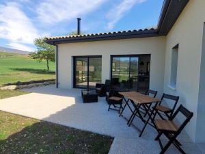 a patio with tables and chairs next to a house at L'Etape de Charme in Bourdeaux