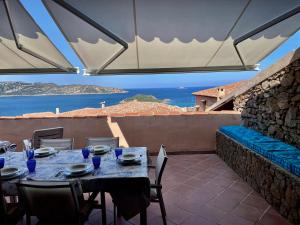 a table with chairs and a view of the ocean at Punta Est - Trilo LAVANDA Terrazza & Piscina in Capo Coda Cavallo