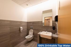 a bathroom with a toilet and a sink and a mirror at Old Town Guest Accommodation in Kranj