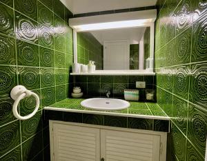 a green tiled bathroom with a sink and a mirror at Punta Est - Trilo LAVANDA Terrazza & Piscina in Capo Coda Cavallo +16 photos
