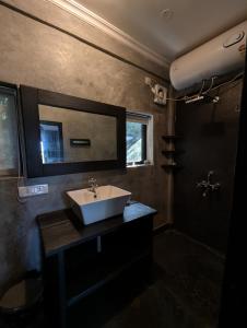 ein Badezimmer mit Waschbecken und Spiegel in der Unterkunft The Double V Experience in Arambol + 25 Fotos