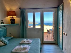 a bedroom with a bed with a view of the ocean at Punta Est - Trilo LAVANDA Terrazza & Piscina in Capo Coda Cavallo