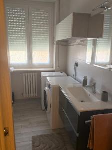 a bathroom with a sink and a washing machine at Sabry house in Novi Ligure
