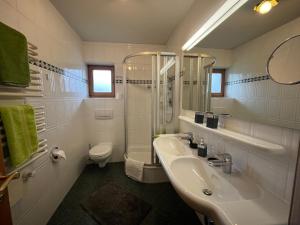 a bathroom with a sink and a shower and a toilet at Frühholz - Das Ferienhaus - in Grainau +52 photos