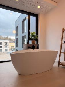 a large white bath tub in a bathroom with a window at Alte Weberei in Marktredwitz +47 photos