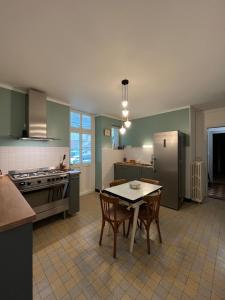 a kitchen with a table and chairs and a refrigerator at Gîte Chez Mamie Madeleine in Ainay-le-Château