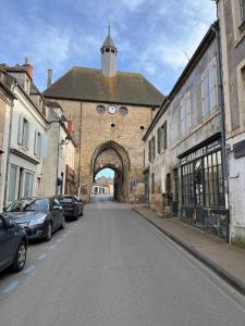 an old building with an archway on a street at Gîte Chez Mamie Madeleine in Ainay-le-Château +6 photos