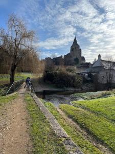 a group of people standing on a bridge over a river at Gîte Chez Mamie Madeleine in Ainay-le-Château