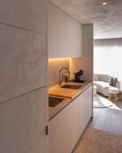 a kitchen with white cabinets and a sink at Groenendijk 8 in Oostduinkerke