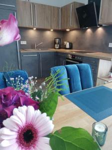 a kitchen with a table with a vase of flowers at FEWO-Boddenblick-Vilm in Lauterbach