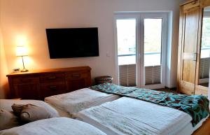 a bedroom with two beds and a flat screen tv at FEWO-Boddenblick-Vilm in Lauterbach