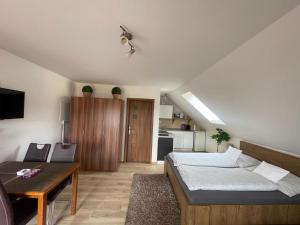 a bedroom with a bed and a table and a kitchen at Apartmany Star in Liptovský Mikuláš