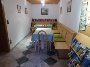 een eetkamer met een tafel en stoelen en boeken bij Haus Siebenbruenn in Sankt Stefan an der Gail