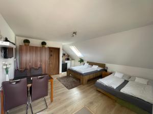 a bedroom with two beds and a table and a kitchen at Apartmany Star in Liptovský Mikuláš