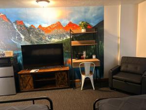 a room with a tv and a table and a chair at Jefferson Inn in Whitehall