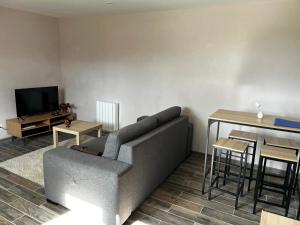 a living room with a couch and a table at Fully equipped, independent apartment in Marles-en-Brie