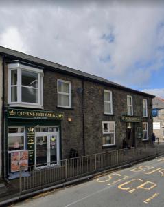a brick building on the side of a street at The Queens Hotel in Rhondda