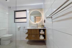 a bathroom with a sink and a toilet and a mirror at Oyster Box Guesthouse in Walvis Bay