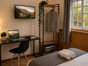 a bedroom with a suit on a mannequin and a desk at Casa da Marquês in Petrópolis