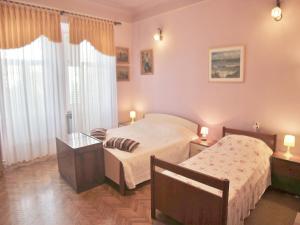 a bedroom with two beds and a table with lamps at Apartment Butković 312 in Pula