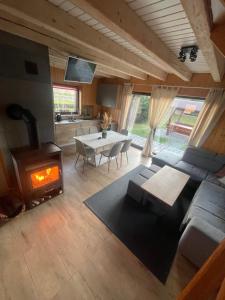 a living room with a couch and a table with a fireplace at Luma Hause & Spa Karkonosze in Wojcieszyce